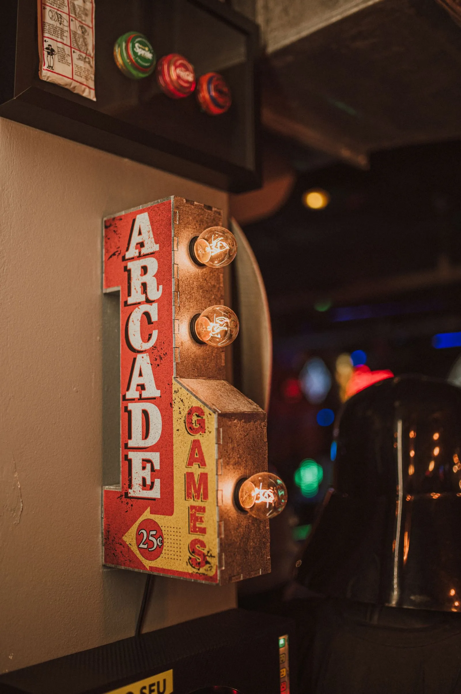 Placa vintage iluminada de fliperama com os dizeres "Arcade Games"